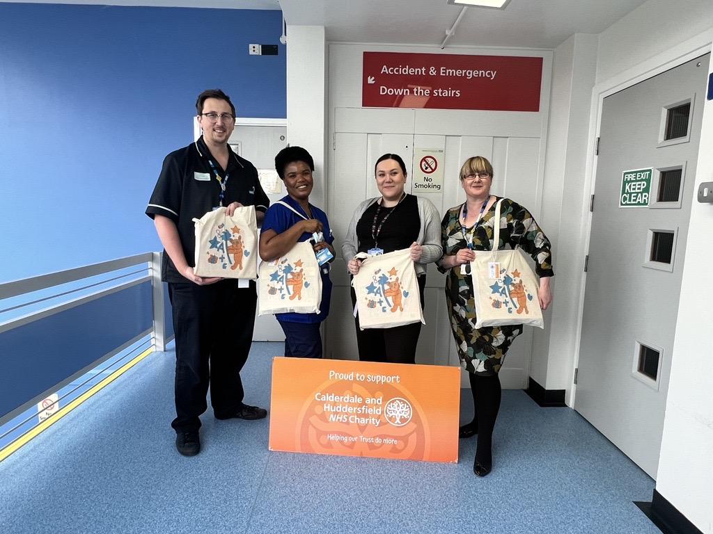 Group of colleagues holding A&E care bags.