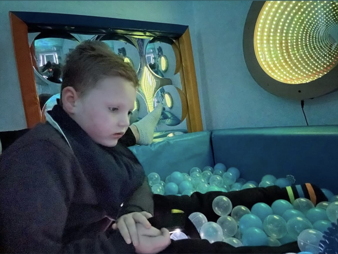 Young boy playing in ball pit.